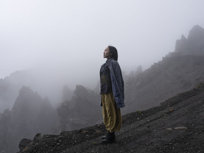 © Sarah Rhodes - The woman fills her lungs with dense foggy air on the edge of the mountain that mimics the topography of her homeland Japan.