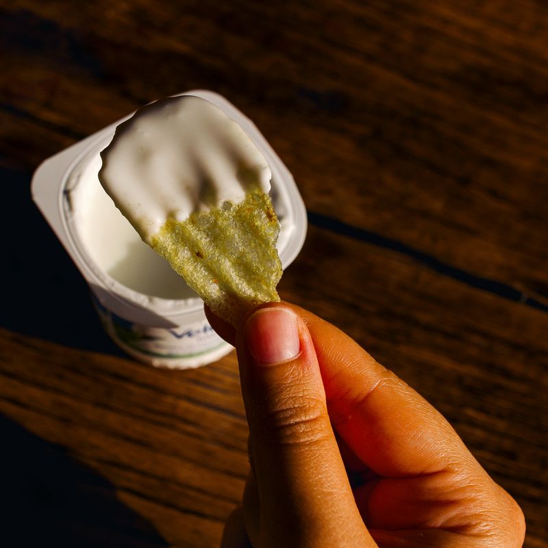 © Olivia de Villaine - Parastoo dips a potato chip in yogurt, a snack many people in Iran grew up with.