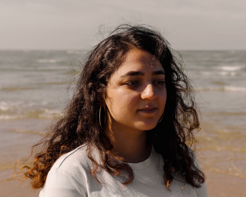 © Olivia de Villaine - Parastoo on the beach, her hair lifted by the wind. She says it is the one place where she never feels sad, only hopeful.