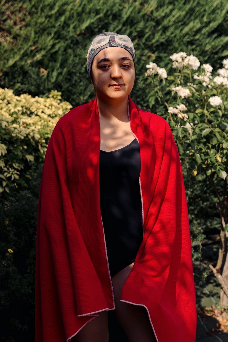 © Olivia de Villaine - Parastoo after a swim, wrapped in a red towel in the garden. She has been swimming since the age of three.
