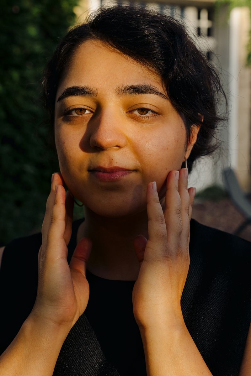 © Olivia de Villaine - Close portrait of Parastoo, her hands on her cheeks, a gesture she often makes, looking straight at the camera.