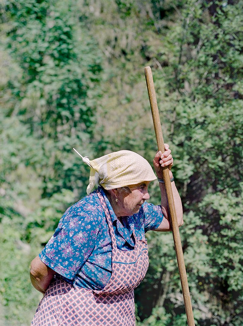 © Claudia Mann - Monica Pallestrong, 84, rests while collecting hay on her property in Rina.