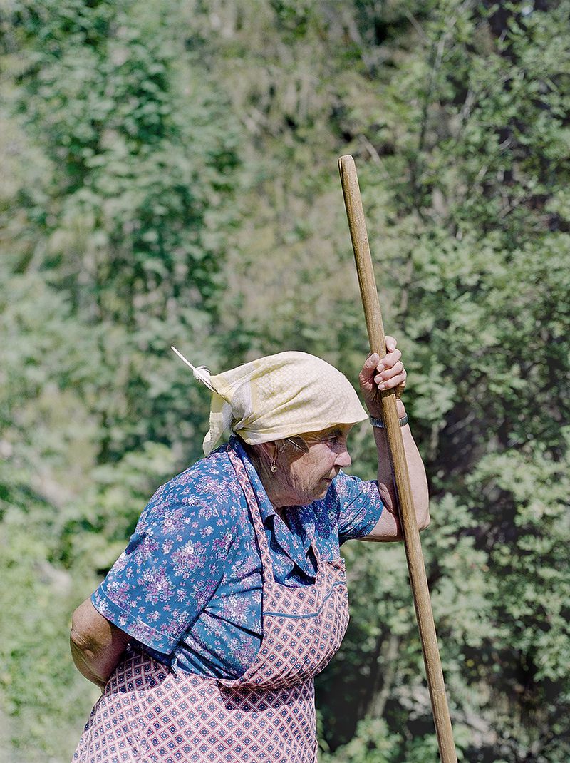 © Claudia Mann - Monica Pallestrong, 84, rests while collecting hay on her property in Rina.