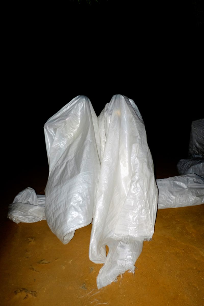 © Santiago Escobar-Jaramillo - At the end of the intervention, two villagers wrap themselves in the white tarpaulin.