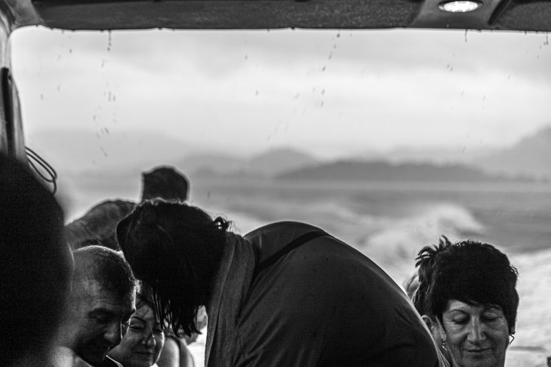 © Nikolay Epifanov - Smile. Tourists on the boat having fun because of heavy rain conditions.