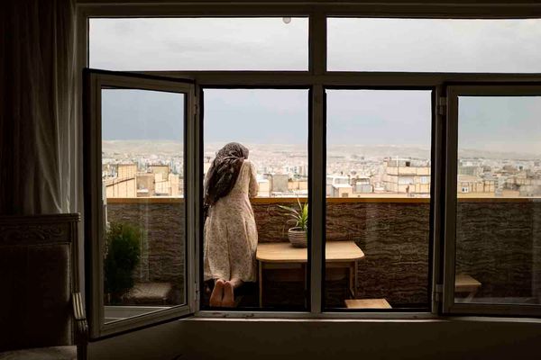 © sima choubdarzadeh - Maryam is looking her son who is playing at the alley.