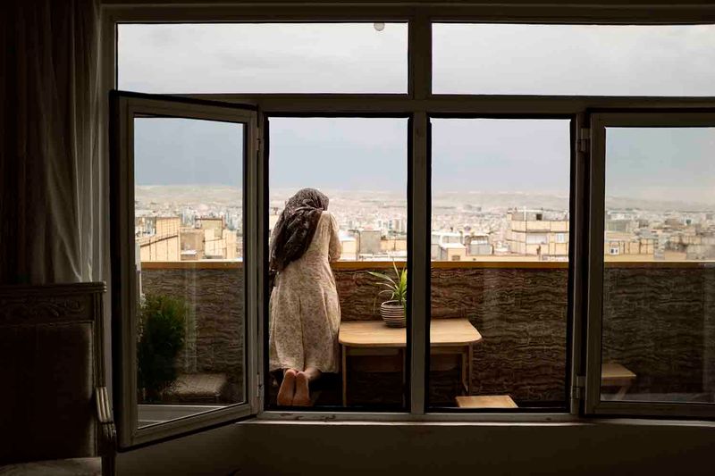 © sima choubdarzadeh - Maryam is looking her son who is playing at the alley.