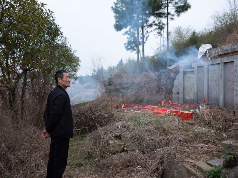© Shina Peng - Uncle praying at the first Peng's grave site. Supposedly the first Peng to immigrate to Linxiang was in the 1300s.