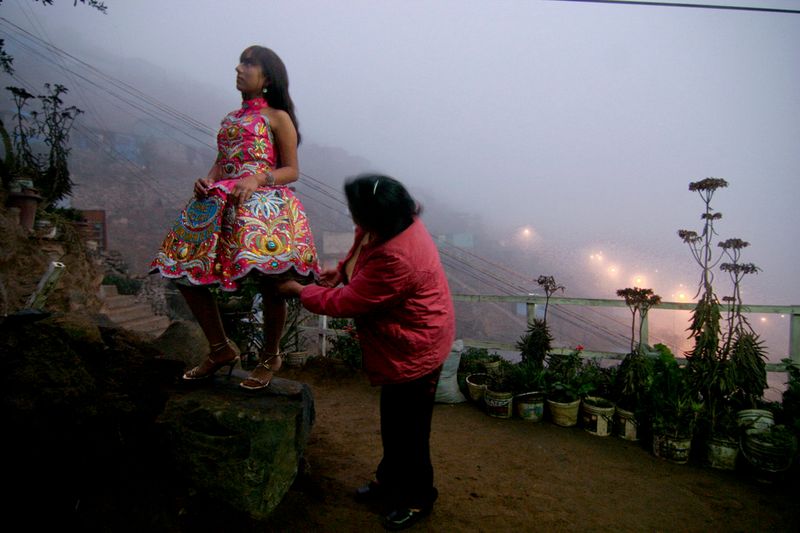 © Max Cabello Orcasitas - Yanet Acuna se prueba el nuevo vestuario de cantante en el patiio de su casa. Su madre la ayuda a probarse la Pollera.