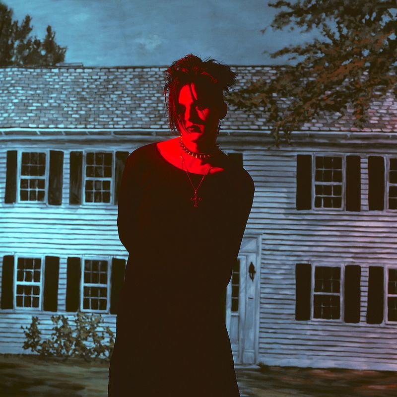 © Steven Edson - Goth man bathed in red light in front of house