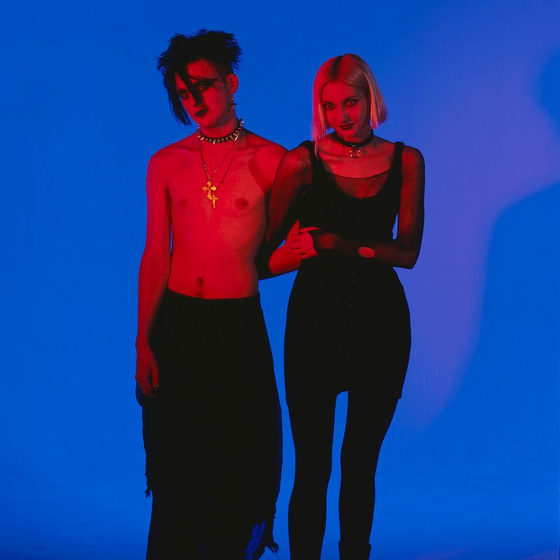 © Steven Edson - Portrait of Goth couple in red light against a blue background