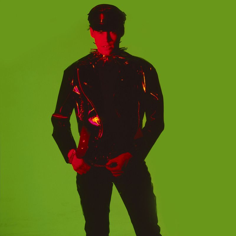 © Steven Edson - Young man in black vinyl outfit against rich green background