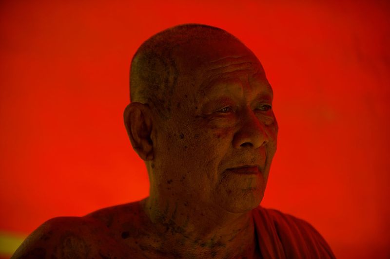 © Steven Edson - Buddhist monk against red tarp . Ayutthaya, Thailand