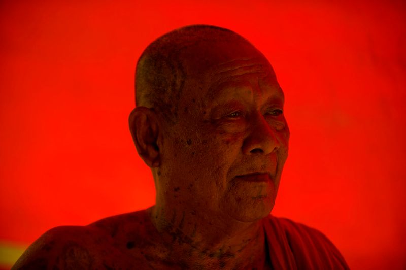 © Steven Edson - Buddhist monk against red tarp . Ayutthaya, Thailand