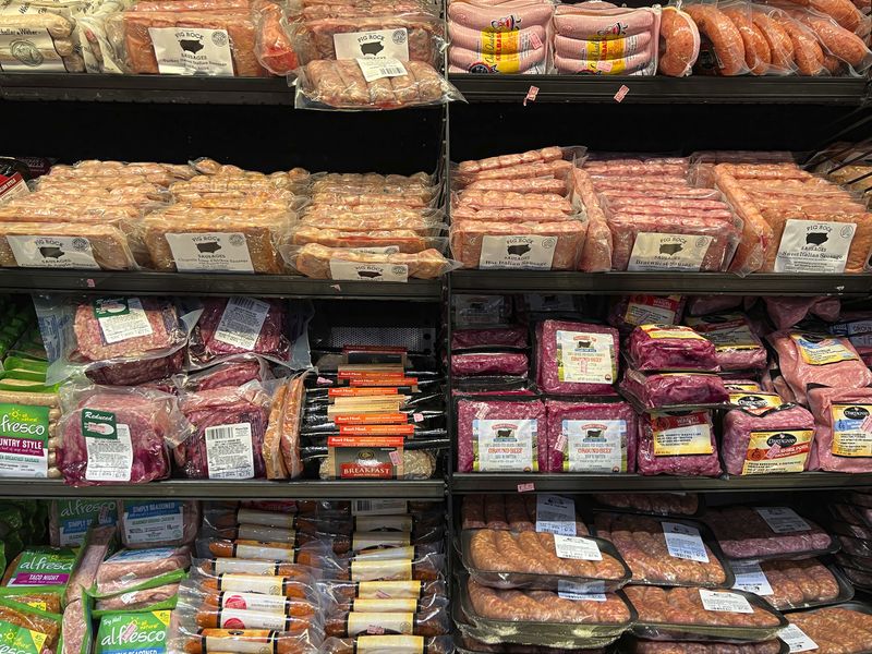 © Steven Edson - Assorted packaged meats in open refrigeratored cold case.