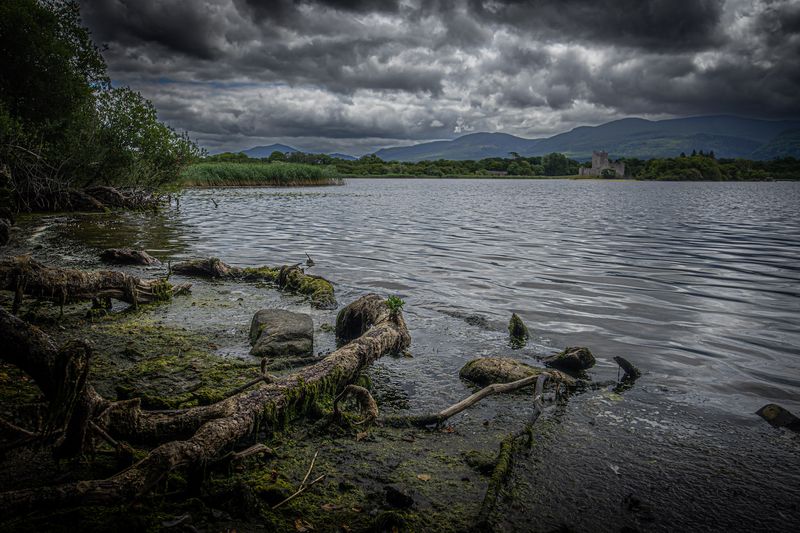 © Cody Ryan Tippie - King's Forsaken; Castle in the distance with a sticked man found floundered and fallen in the shallows opposite the bank.