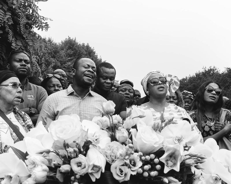 © Rebecca  Fertinel - People are crying and singing for the deceased family member