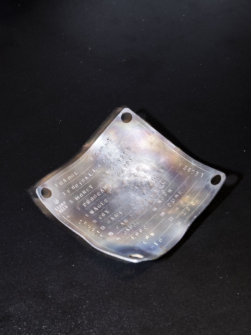© Enka Springub - Titanium plate with an embossed seed phrase after a fire.