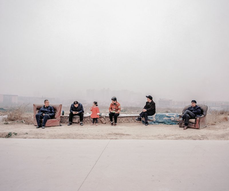 © Pan Wang - 06.Farmers sit in front of a strip of expropriated land behind them that was once an orchard