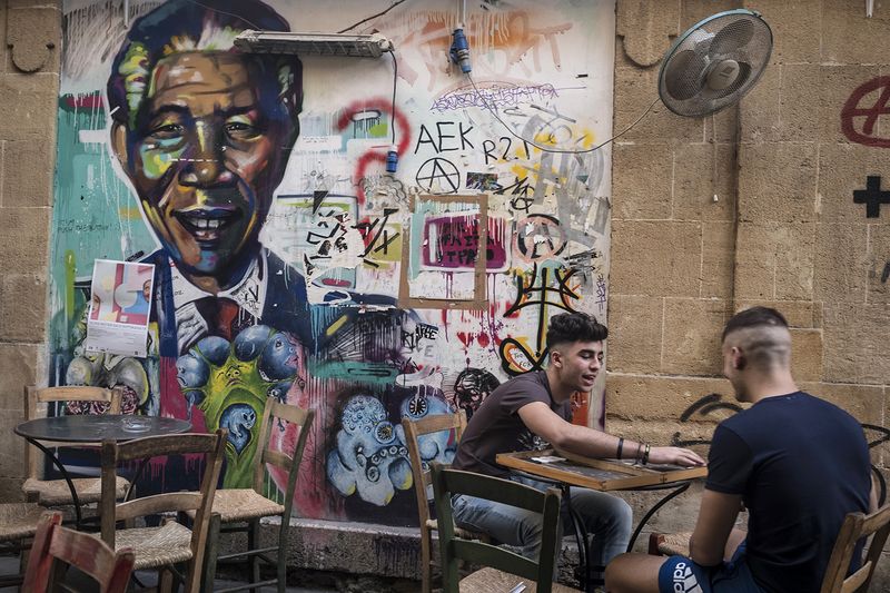 © Sahan Nuhoglu - Two Cypriot youngsters are playing black gammon in front of a Mandela mural in the city of Nicosia, Cyprus.