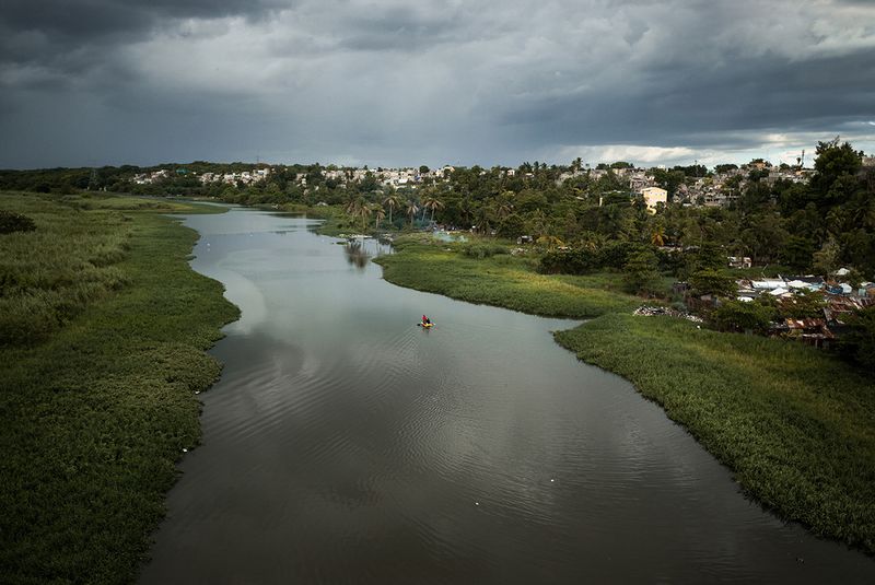 © Benjamin Petit - Teenagers use a canoe to move along La Barquita on the Ozama river. Santo Domingo, Dominican Republic. September 8, 2015.
