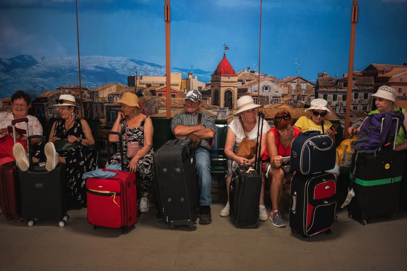 © Christopher Jones - Tourists in port terminalCorfu Port.Passengers wait with their luggage inside the international port terminal.