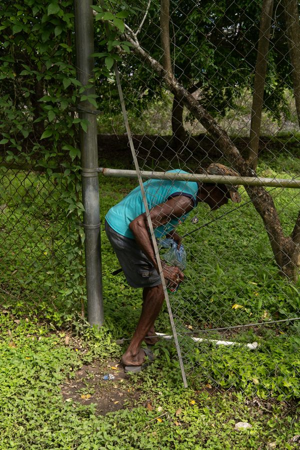 © Tova Katzman - Brown crossing the Panama Port Authority fence to fish in the Canal waters, 2021