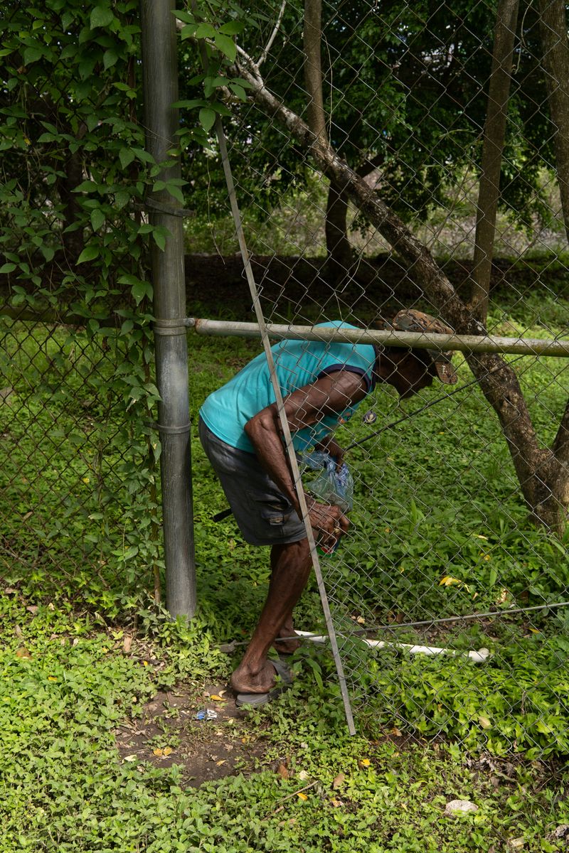 © Tova Katzman - Brown crossing the Panama Port Authority fence to fish in the Canal waters, 2021