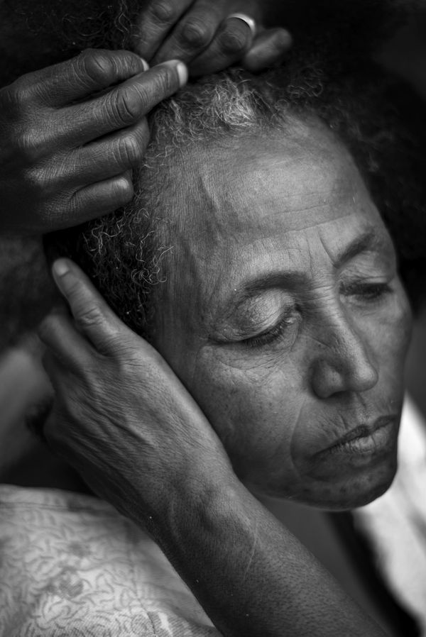 © Ida Guldbaek Arentsen - A group of women sit on the wide steps leading down to one of the hospital wards braiding each other’s hair.