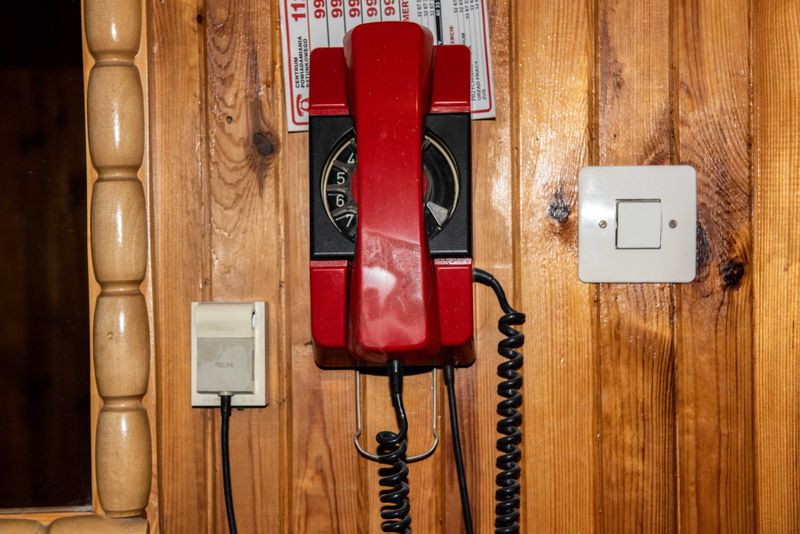 © Zula Rabikowska - Classic wooden wall panels with a telephone and a list of emergency contact numbers.