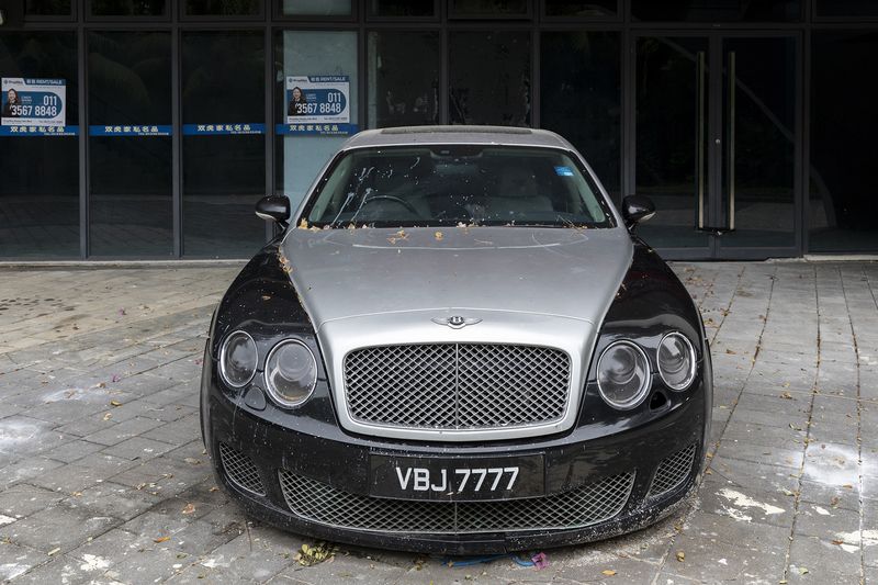 © Francesca Pompei - A luxury car abandoned in front of old vehicles' resellers of Forest City.