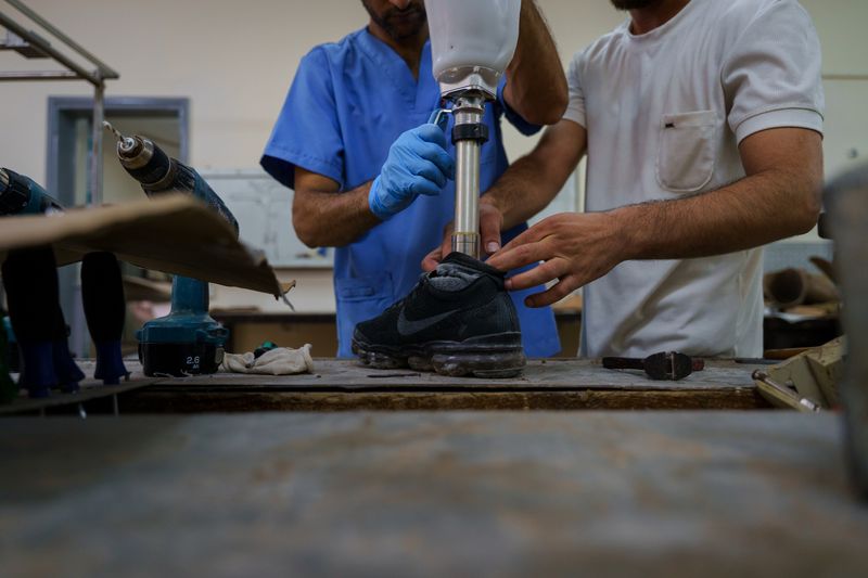 © Maxime Le Lijour - Technicians fit a prosthetic pylon into a shoe at the Artificial Limbs and Polio Centre in Gaza City.