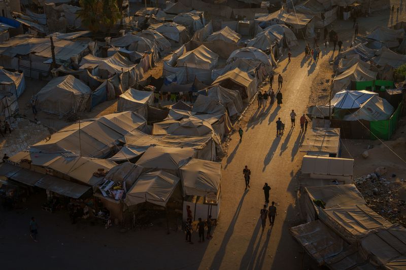© Maxime Le Lijour - People walk near the port at sunset in Gaza City.