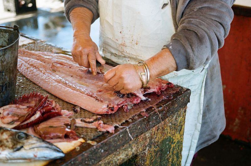 © Celeste Jacobs - A woman prepares the fish for a customer, 2026