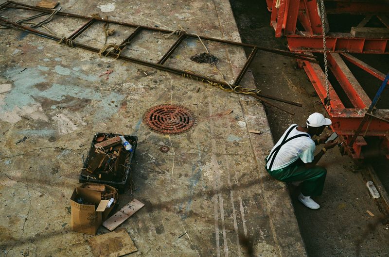 © Celeste Jacobs - A man takes a break from boat repairs, 2026