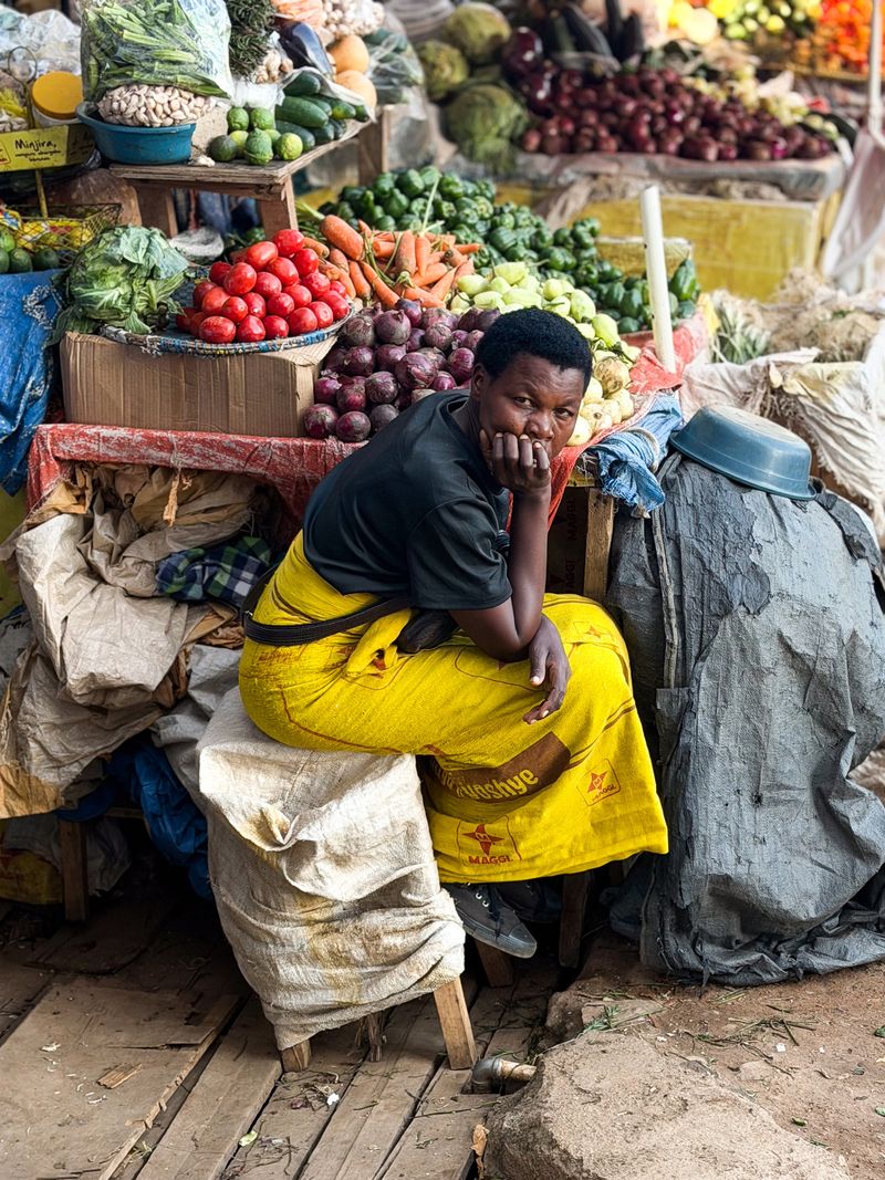 © Zahra Farajasri - Kigali, Rwanda, 2026 - A market vendor surrounded by fresh produce in Kigali.