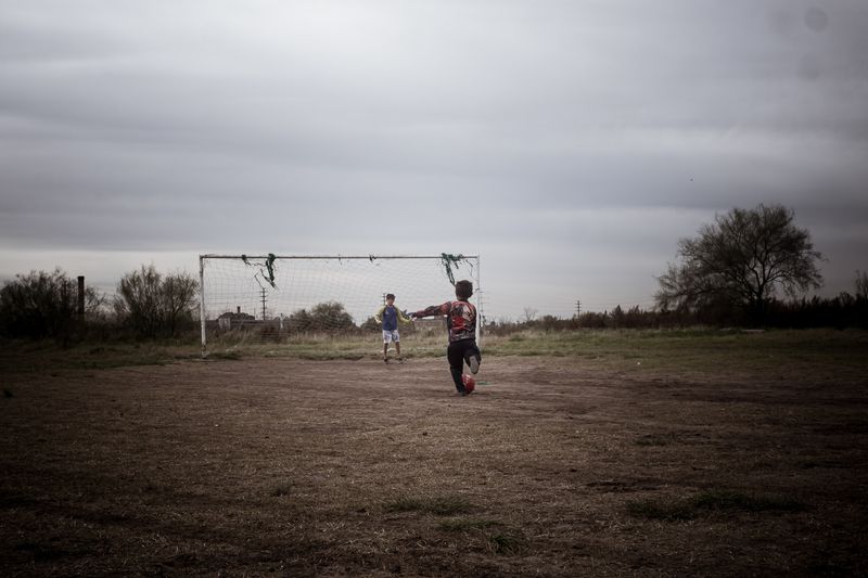© Daniella Fernandez - In Villa Inflamable, Buenos Aires, two children play soccer in a vacant lot surrounded by sources of contamination.