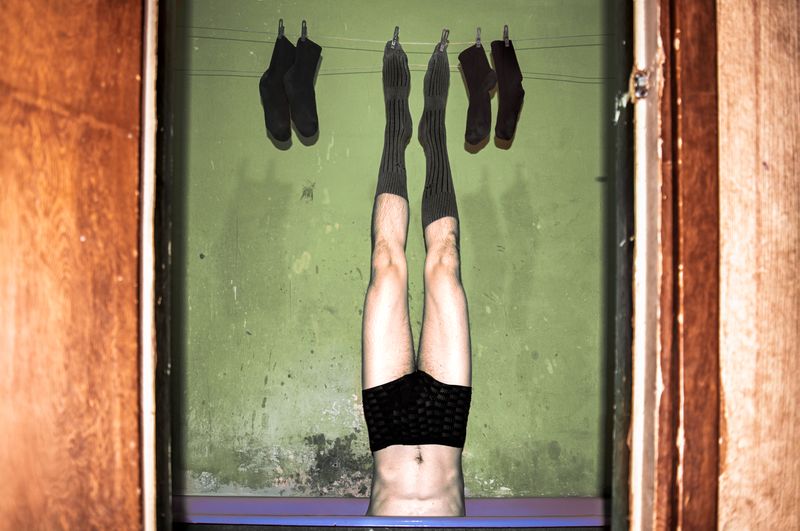 © Yulia Kozynka - "The Hanged Man" | A figure hanged by its toes alongside washed socks