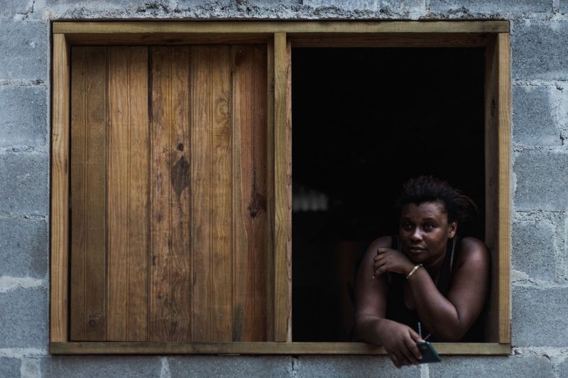 © Salvatore Caruso - A Garifuna woman watches over her son playing in the street from the window of her home.