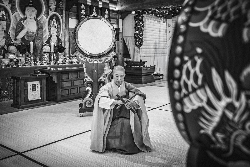 © Min A Choi - Hands crossed over drumsticks in a quiet pause. Jingwansa Temple, 2026.