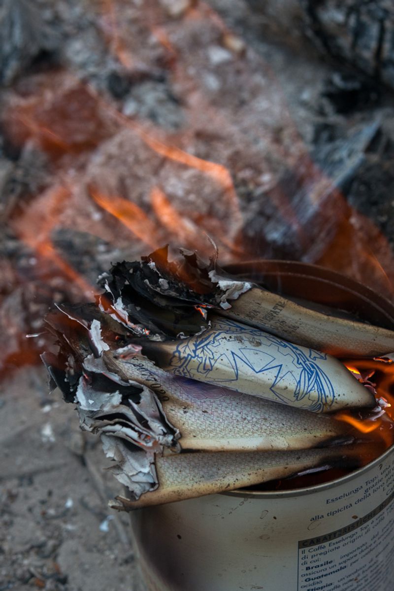 © Rose Lecat - Identity papers left by the exiles who passed in France, burn on the Franco-Italian border. September 20, 2018.