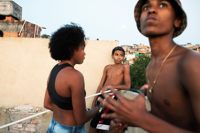 © Sabine van Wechem - Thay is on the rooftop with her friends Marcus and Breninho playing with the kite.