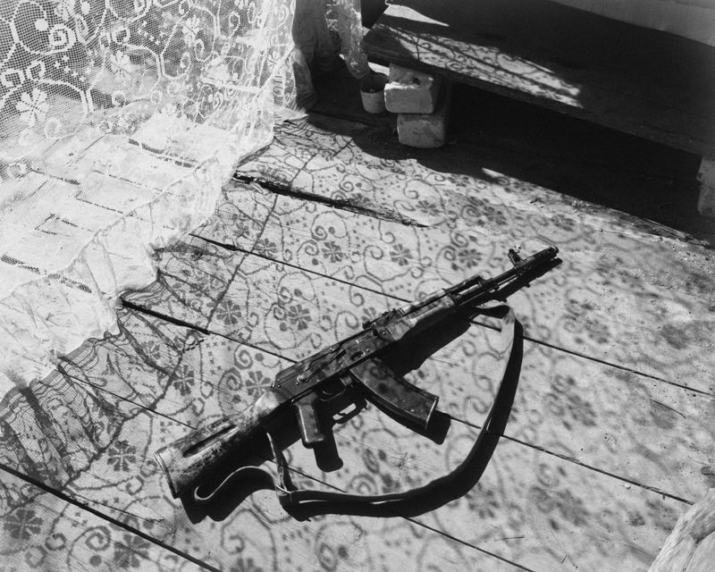 © David Hadland - An AK-74 assault rifle laying on a sunny porch. Kharkiv Oblast 2025.