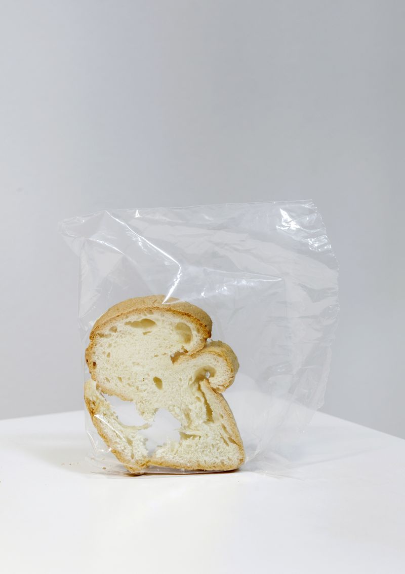 © Lucija Rosc - A piece of dry gluten-free bread that I found in our kitchen, standing upright in the plastic bag, exactly like this.