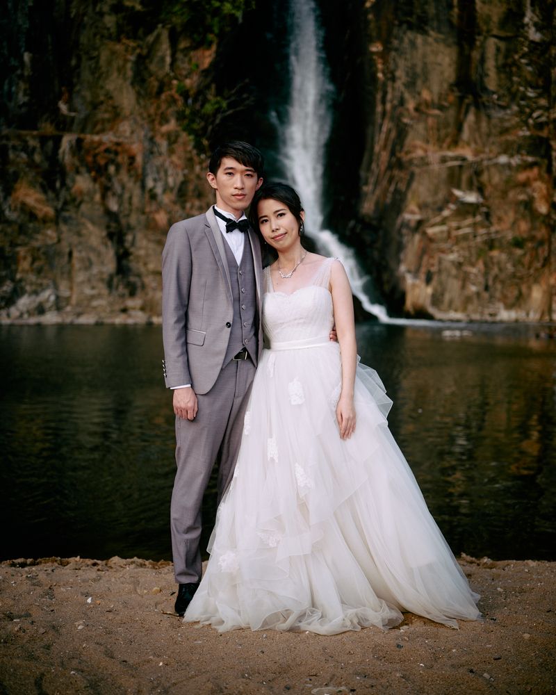 © Chung-wai Wong - Tim and Angel, a couple taking wedding photos in front of Waterfall Bay.