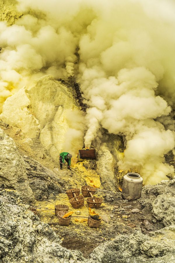 © Manolo Ty - A miner works in the acidic fumes of the vulcano to extract hardened sulfur blocks.