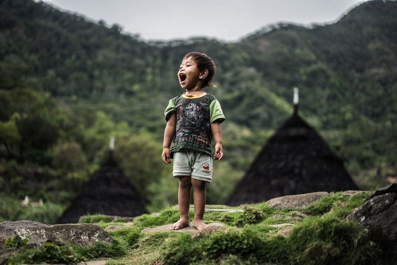 © Manolo Ty - A young boy welcomes visitors to the traditional village Wae Rebo with a smile.