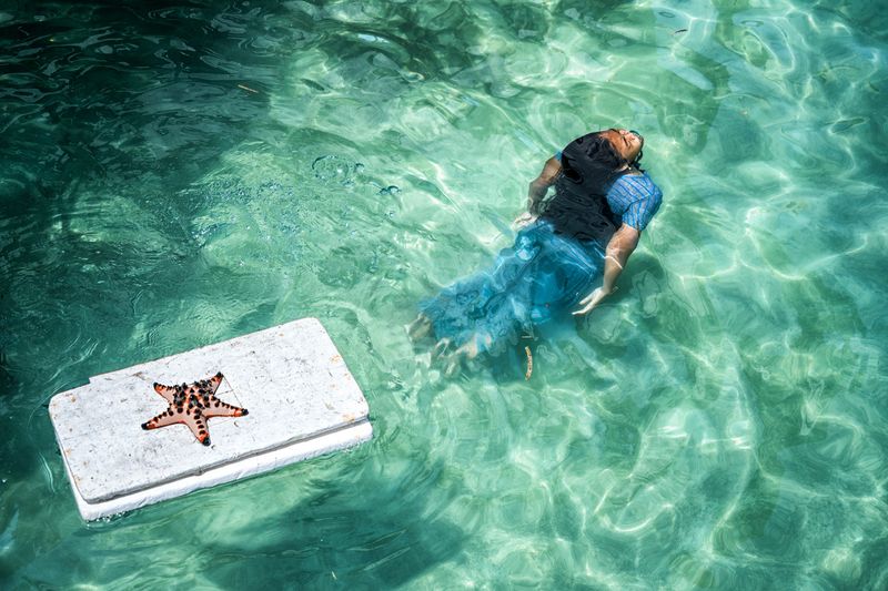 © Manolo Ty - A Bajau girl collects sea stars from the sea floor on Sanana island in the Moluccas.