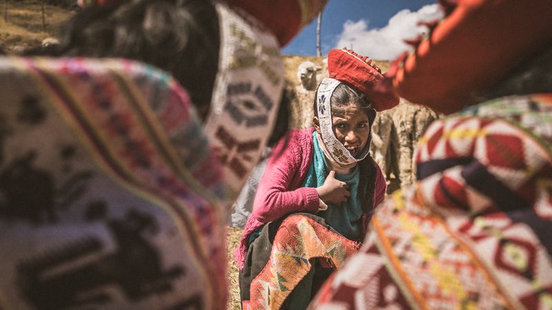 © Javier Gogna - Herencia cerrada. Rodeada por los ponchos, la niña observa. No hay caminos visibles más allá de ellos.