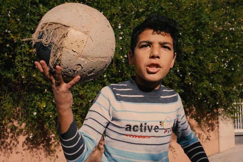 © Habib Saleh - A young boy holds up his worn-out soccer ball. Joun, Lebanon 2023.